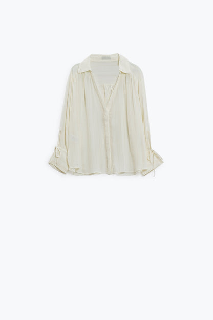 camisa blanca ligera con cuello de pico y detalles de rayas