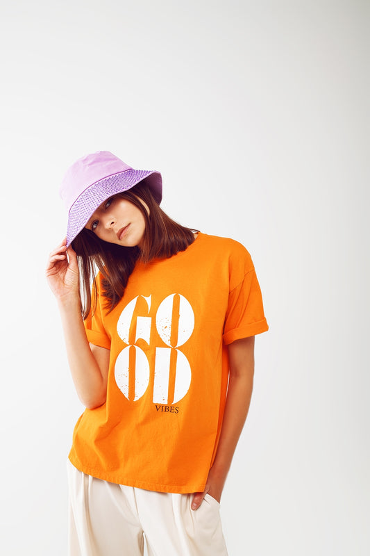 Q2 Camiseta con el texto Good Vibes en naranja