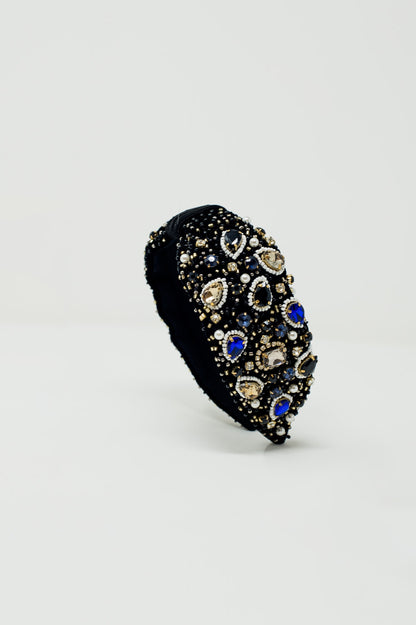 Diadema negra con joyas bordadas grandes y pequeñas.