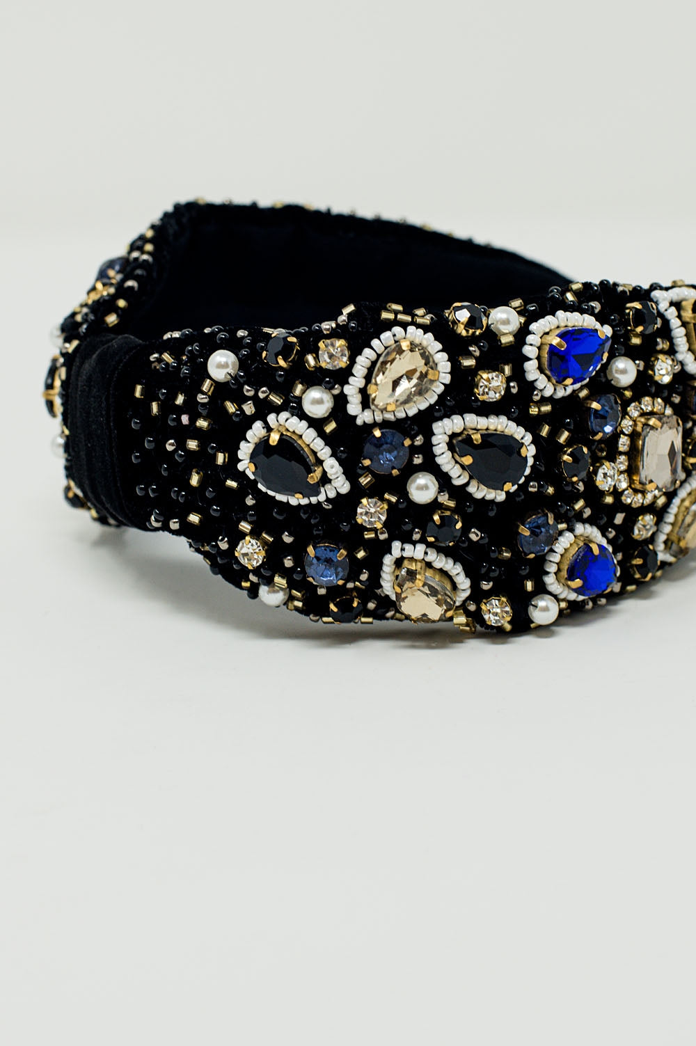 Diadema negra con joyas bordadas grandes y pequeñas.