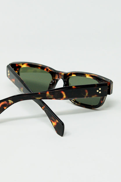 Gafas de sol color ámbar con lentes ovaladas de color verde oscuro
