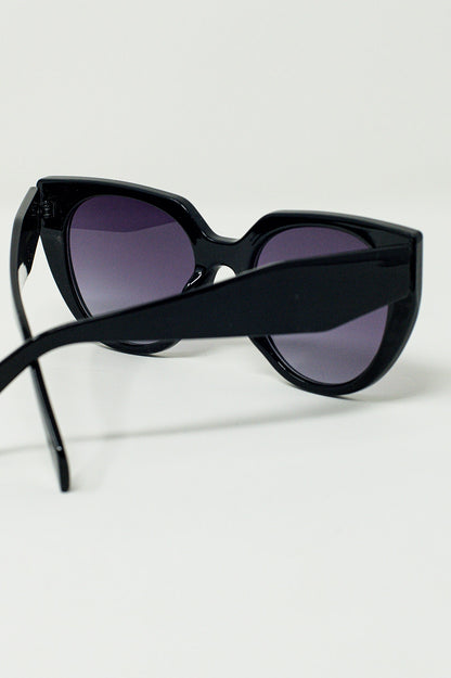 Gafas de sol estilo ojo de gato extragrandes con ribete ancho en negro.