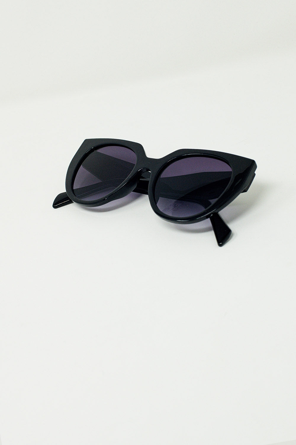 Gafas de sol estilo ojo de gato extragrandes con ribete ancho en negro.