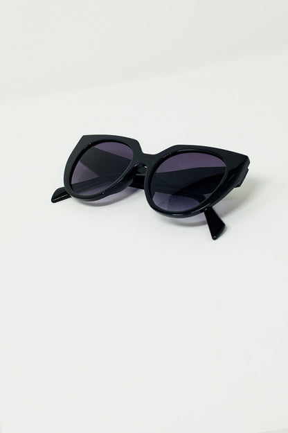 Gafas de sol estilo ojo de gato extragrandes con ribete ancho en negro.