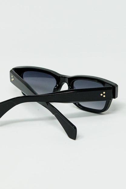 Gafas de sol negras con montura ovalada con detalle dorado