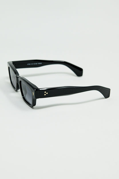 Gafas de sol negras con montura ovalada con detalle dorado