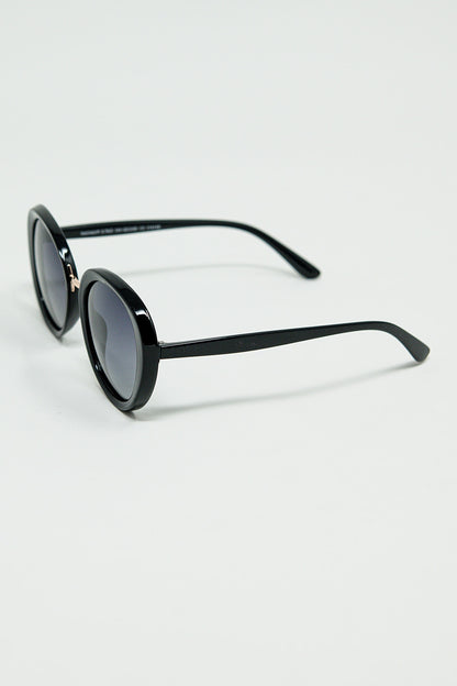 Gafas de sol ovaladas negras con detalle metálico dorado