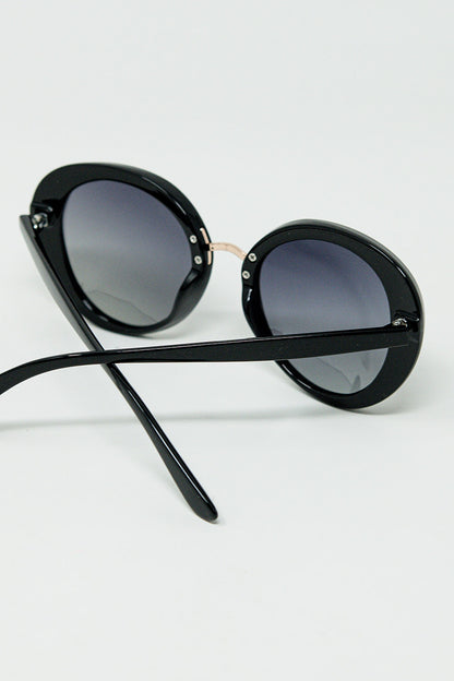 Gafas de sol ovaladas negras con detalle metálico dorado