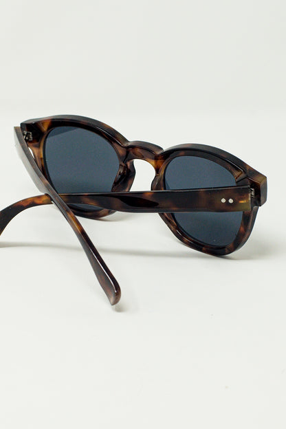Gafas de sol redondas de los 90 con lentes negras y montura de carey marrón oscuro