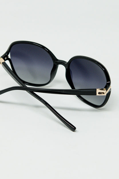 Gafas de sol redondas en negro con detalle metálico dorado