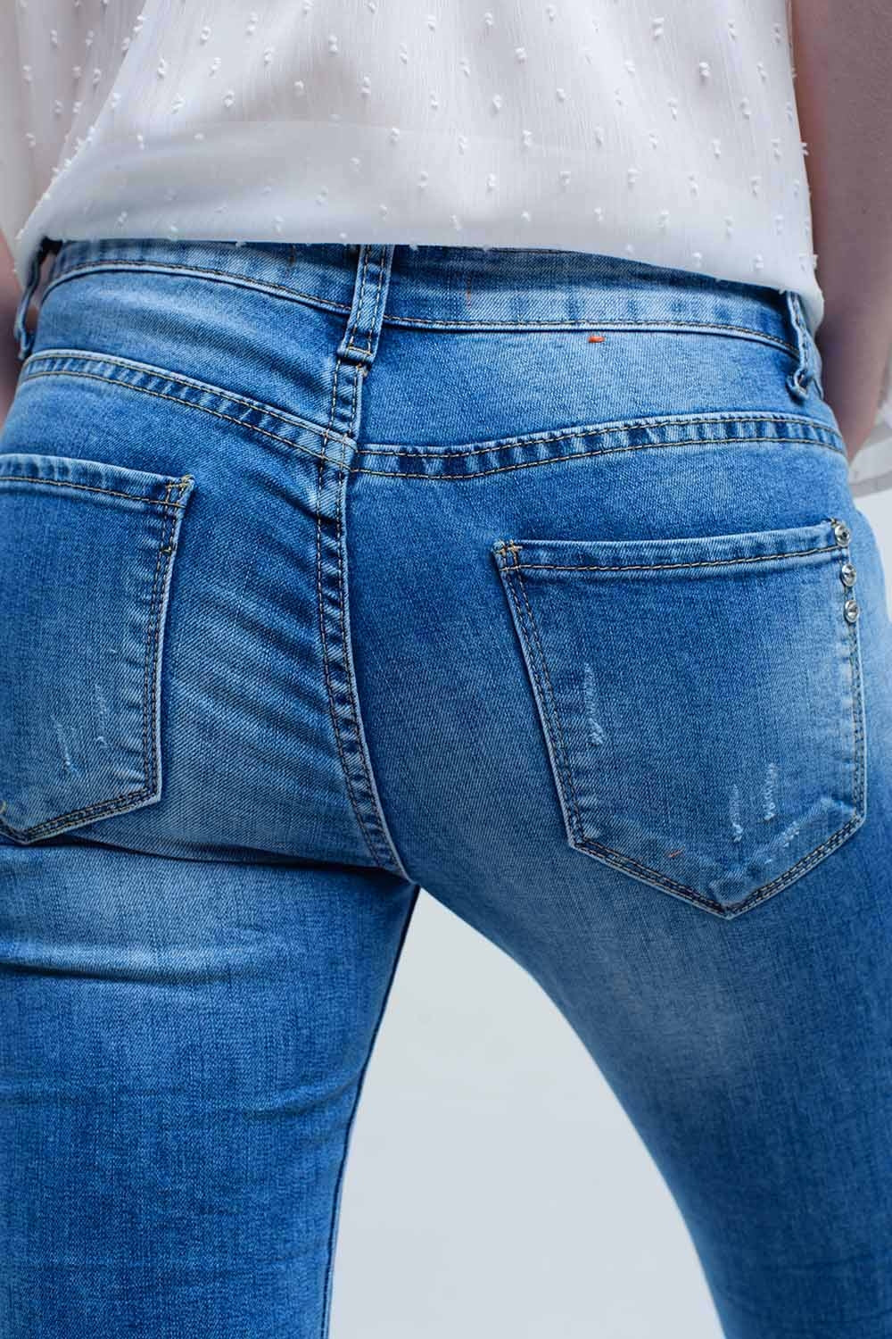 Jeans ajustados de tiro medio con roturas