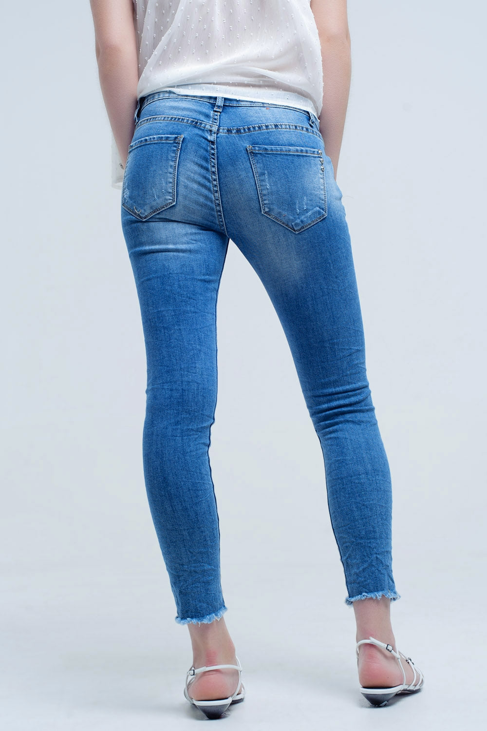 Jeans ajustados de tiro medio con roturas