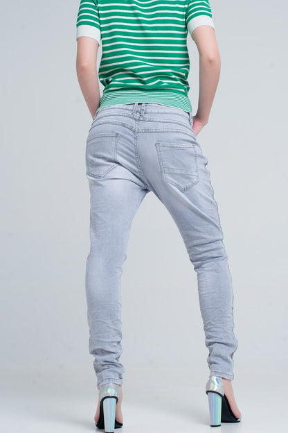 jeans gris con detalles metálicos en el lateral