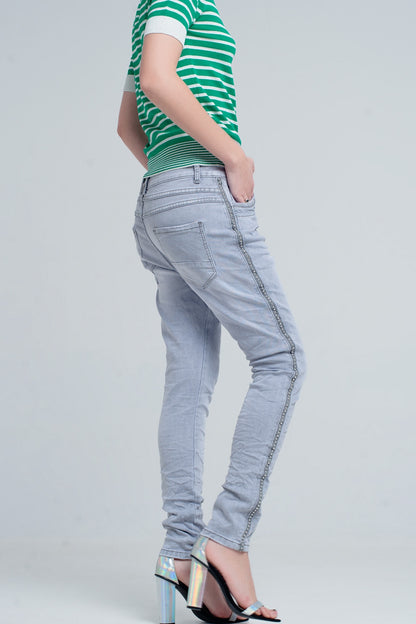 jeans gris con detalles metálicos en el lateral