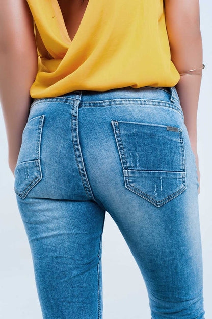 Jeans pitillo en lavado medio con rotos en las rodillas
