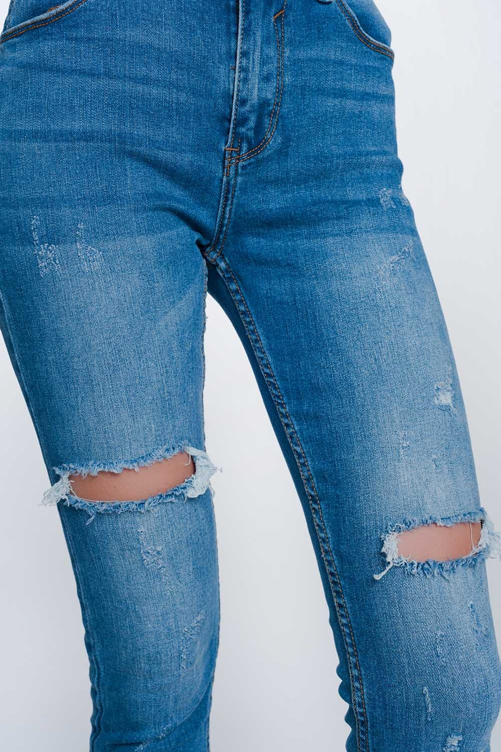 Jeans super ajustados con rotos en la rodilla y el bajo