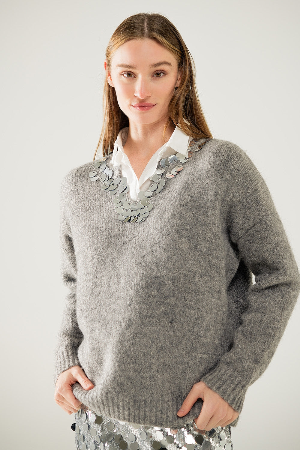 Jersey gris con cuello de pico y detalle de lentejuelas