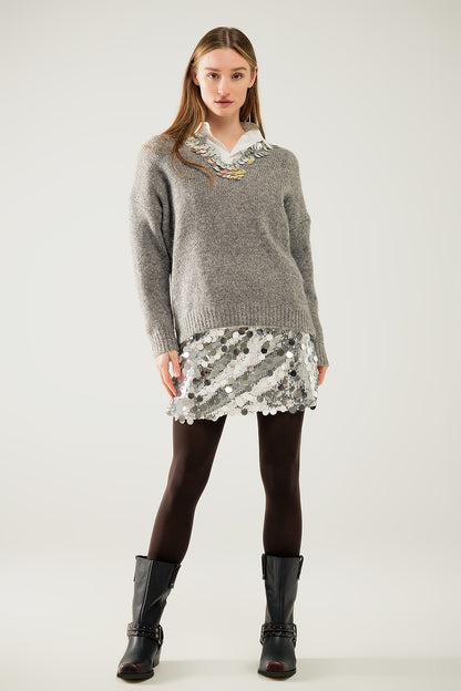 Jersey gris con cuello de pico y detalle de lentejuelas