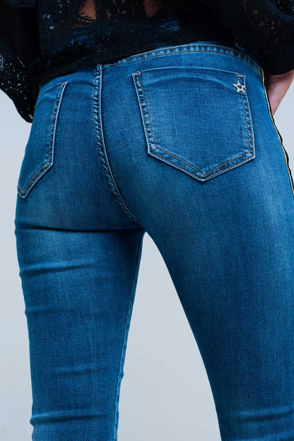 Pantalon vaquero azul con banda lateral dorada y negra