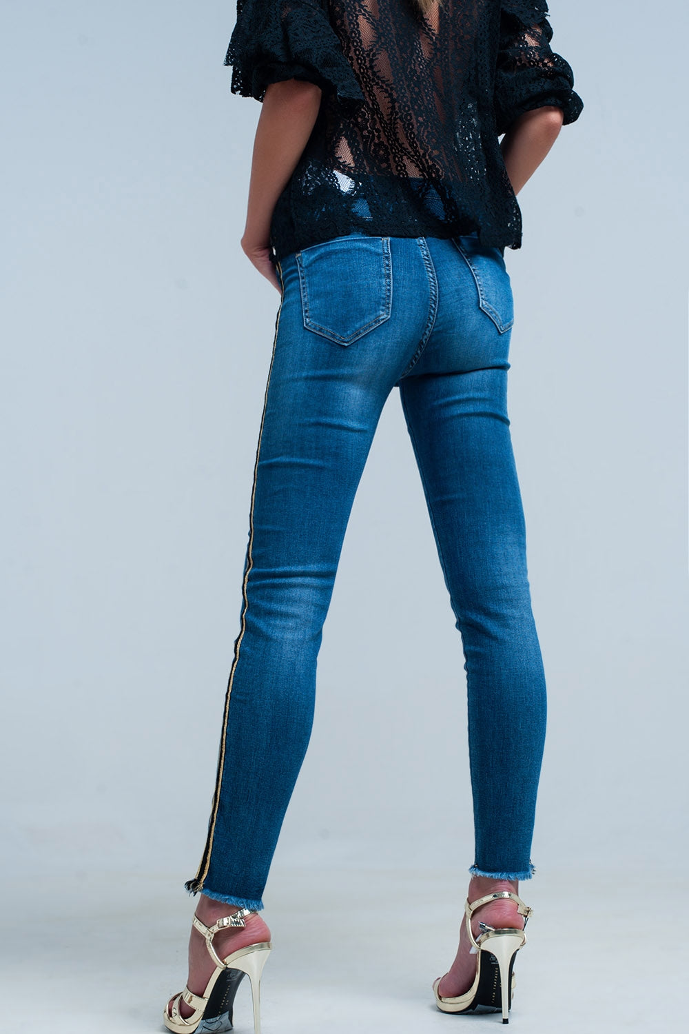 Pantalon vaquero azul con banda lateral dorada y negra