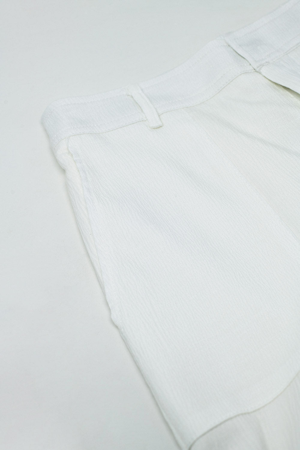 Pantalones blancos de raso con bolsillos laterales y aros para el cinturón