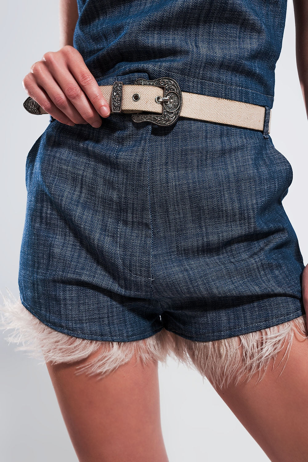 Pantalones cortos de traje color azul con plumas sintéticas en el bajo