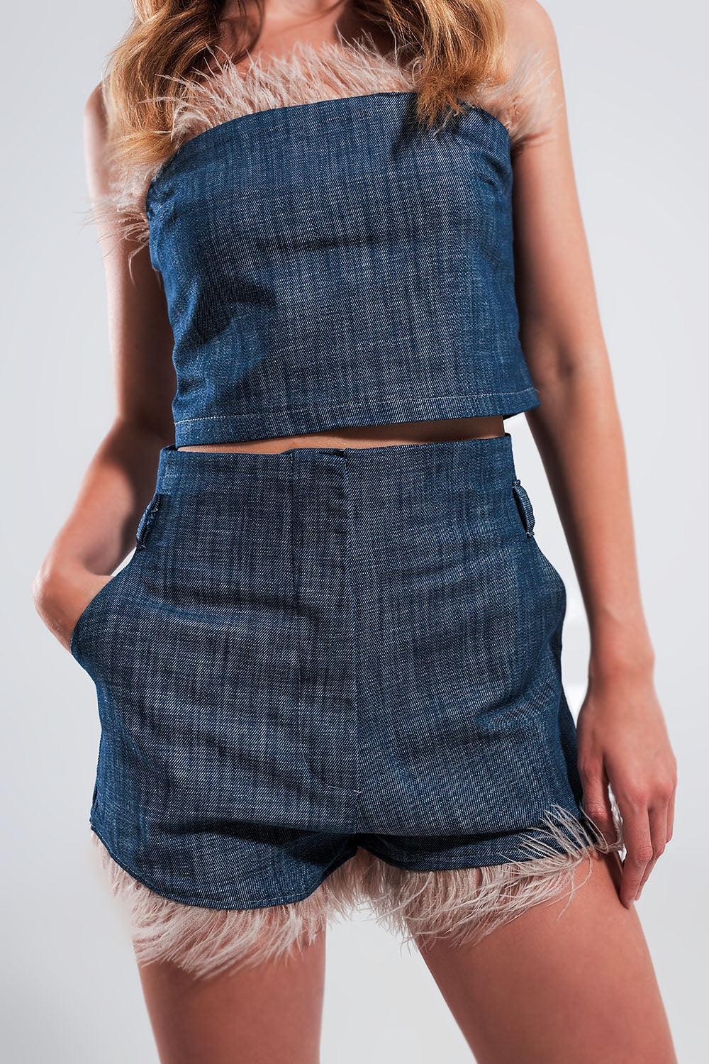 Pantalones cortos de traje color azul con plumas sintéticas en el bajo