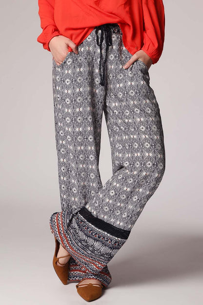 Pantalones de pernera amplia con estampado etnico azul y detalle de puntilla