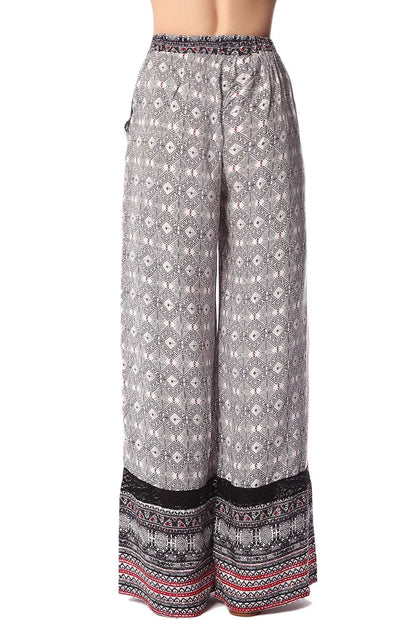 Pantalones de pernera amplia con estampado etnico negro y detalle de puntilla