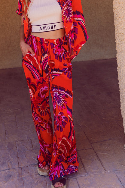 Pantalones estilo palazzo con estampado floral abstracto en naranja