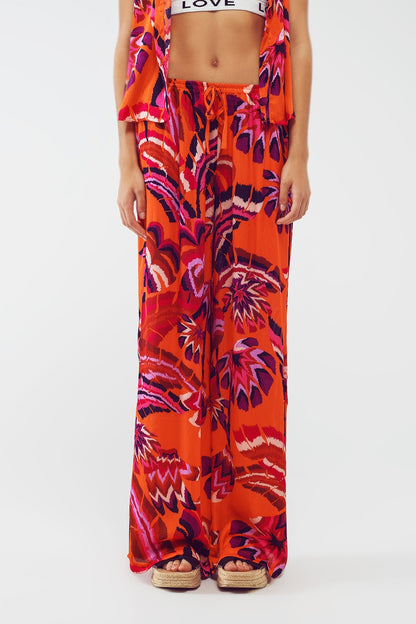 Pantalones estilo palazzo con estampado floral abstracto en naranja