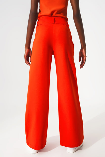 Pantalones naranja de pernera ancha y detalle de botones
