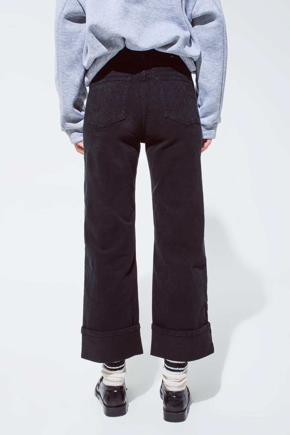 Pantalones vaqueros rectos en negro con perneras dobladas