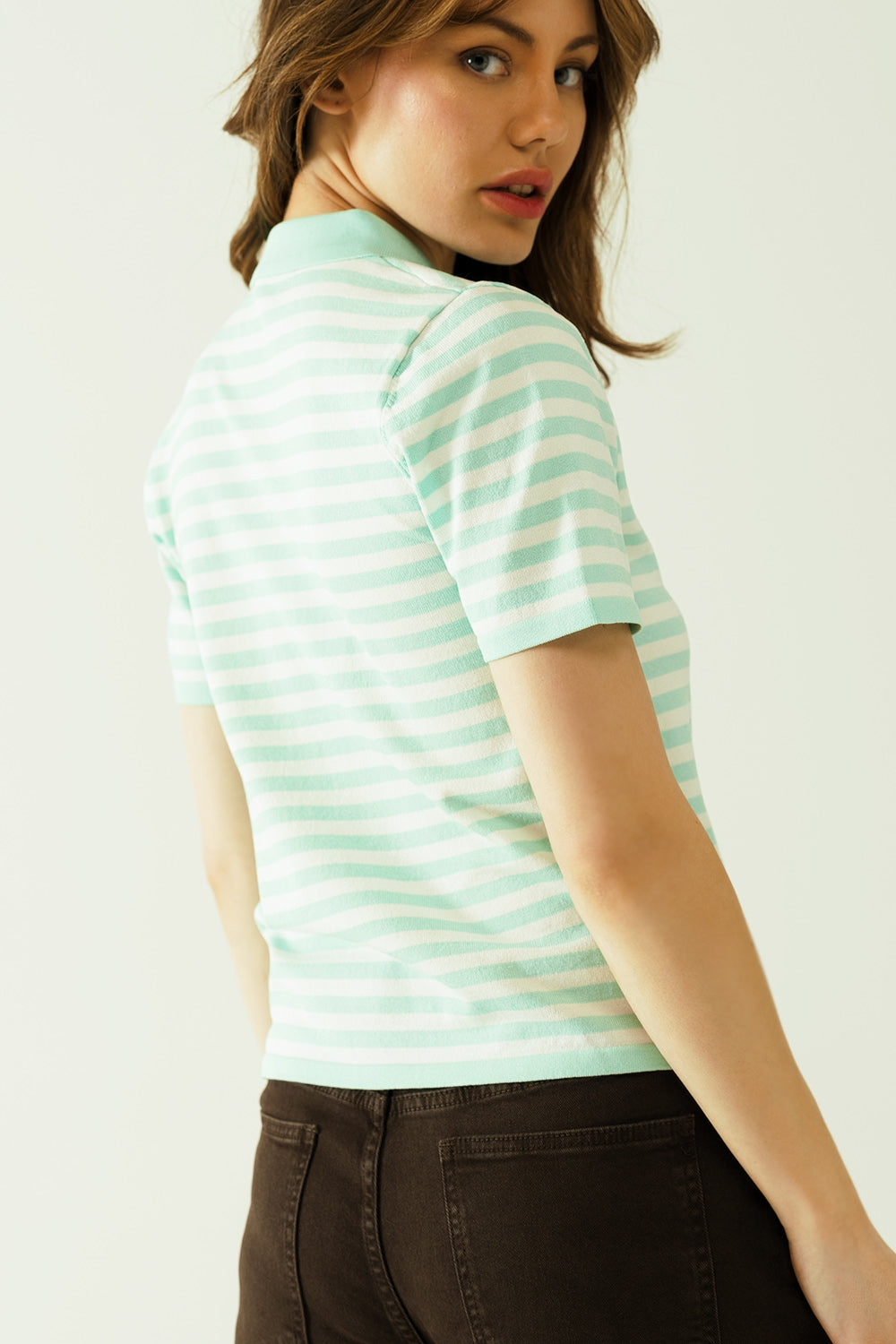 Polo blanco de manga corta con rayas azul claro y detalles de botones frontales