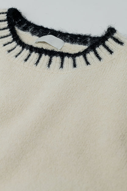 Suéter esponjoso de color crema con detalles de canalé en el cuello y el bajo