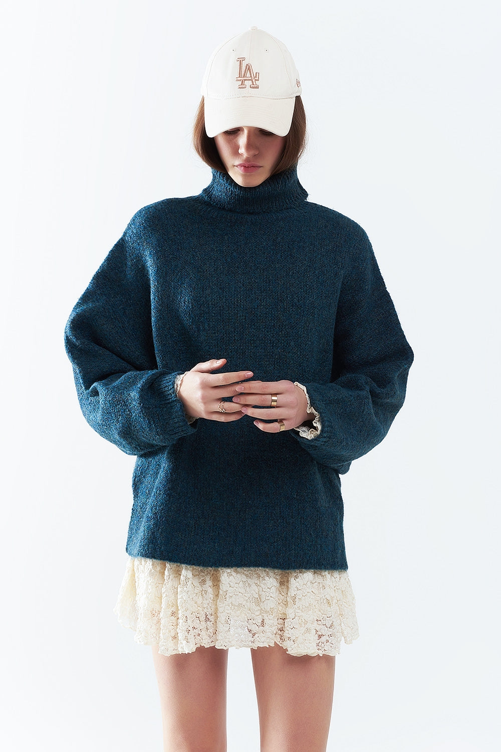 Suéter oversize en color verde azulado con cuello alto y mangas sueltas.
