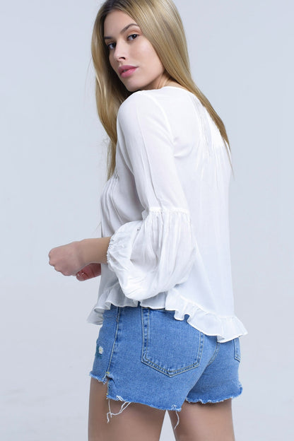 Top blanco con detalle anudado y bajo con volante