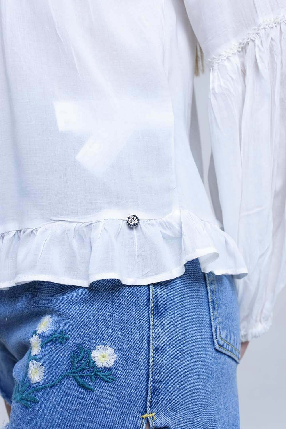 Top blanco con detalle anudado y bajo con volante
