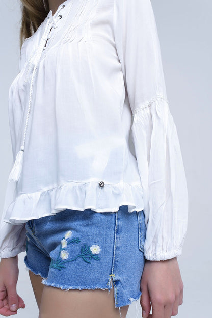 Top blanco con detalle anudado y bajo con volante
