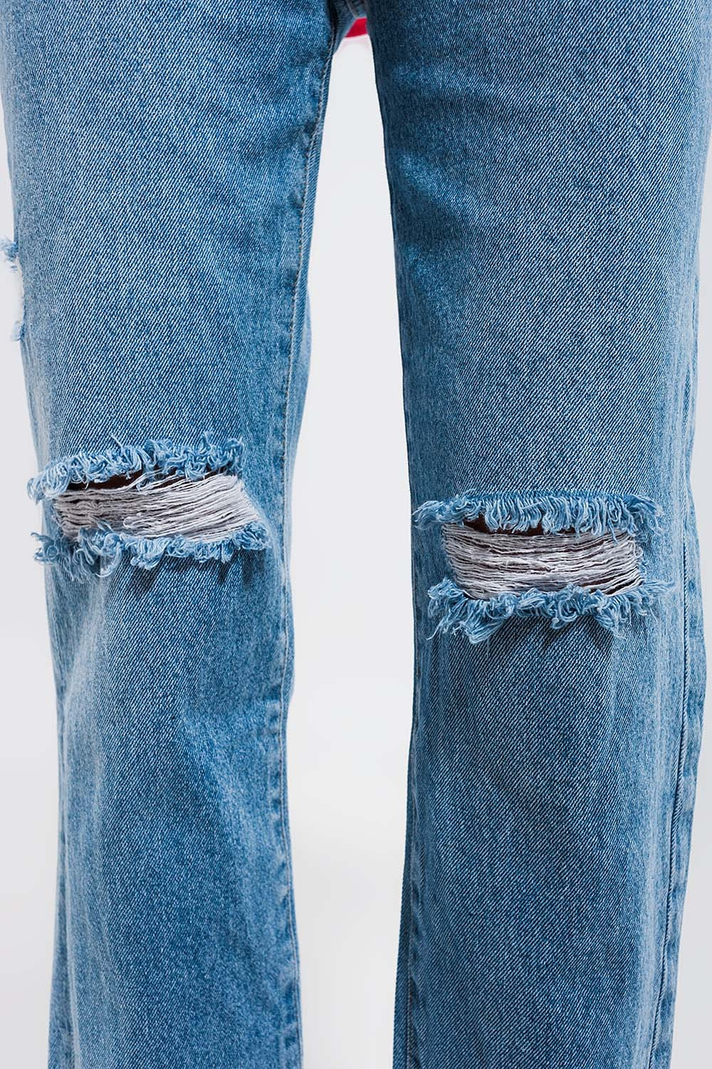 Vaqueros con lavado azul claro y rodillas rasgadas