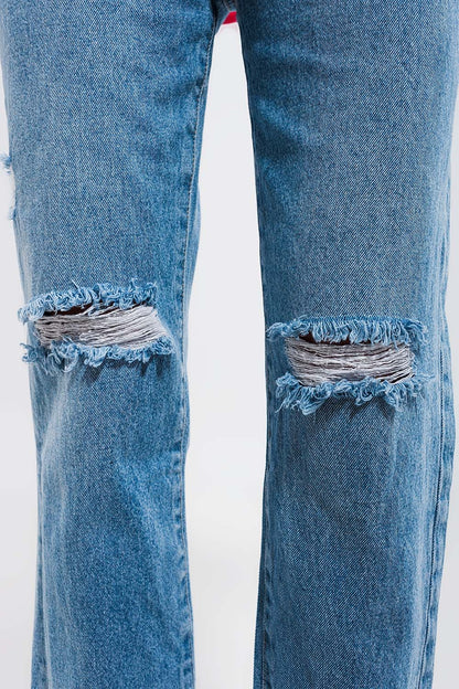 Vaqueros con lavado azul claro y rodillas rasgadas