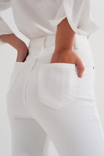 Vaqueros de corte slim con cremallera y botón asimétricos en crema