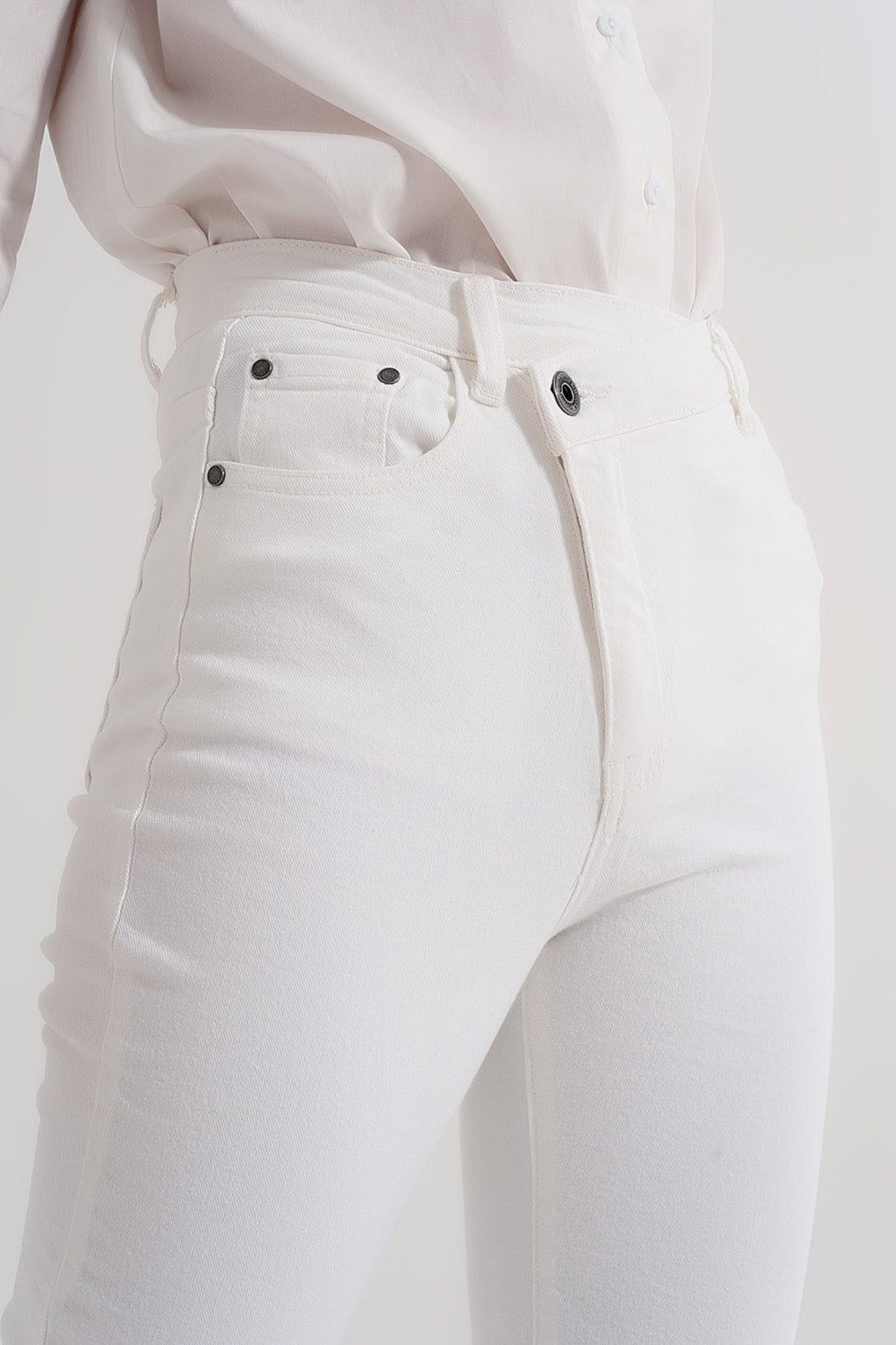 Vaqueros de corte slim con cremallera y botón asimétricos en crema