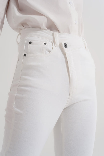 Vaqueros de corte slim con cremallera y botón asimétricos en crema