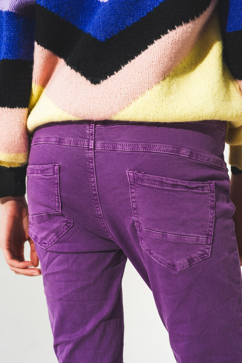 Vaqueros pitillo color morado con botones a la vista
