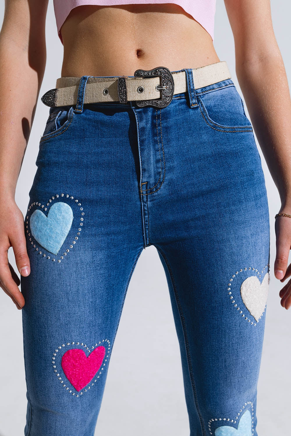 Vaqueros pitillo oscuros con corazones rodeados de tachuelas