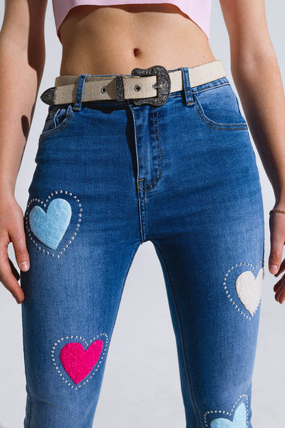 Vaqueros pitillo oscuros con corazones rodeados de tachuelas