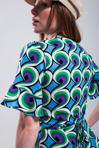 Vestido corto azul cruzado con volantes en el bajo y estampado estilo años 70